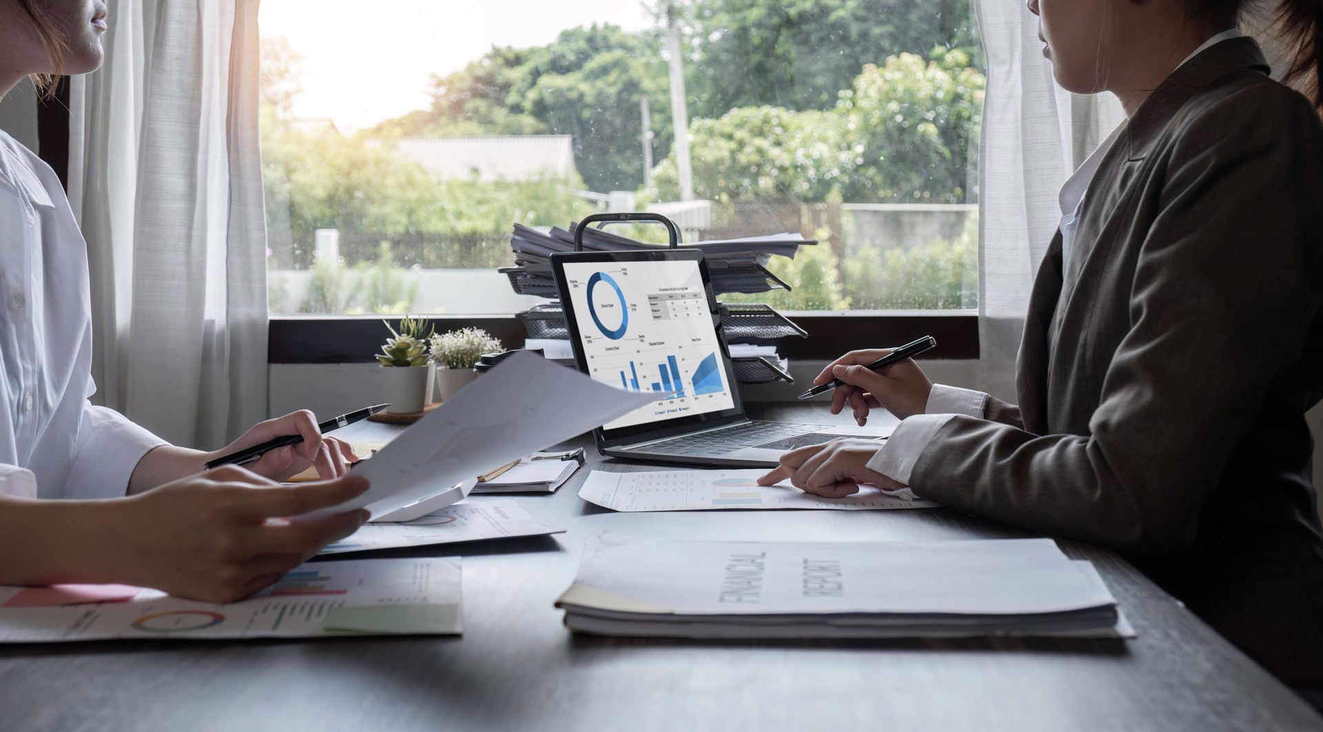 Close-up, A team of accountants and businesswomen sit and work on numbers and graphs. On the laptop on the table in the office